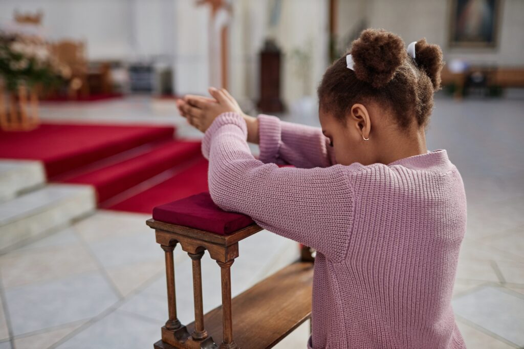 african american little girl praying in church jpg